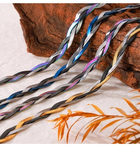 Close-up of multi-colored braided titanium steel snake chains on a natural rustic background