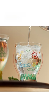Macro view of borosilicate glass cup with waist design and colorful cartoon patterns