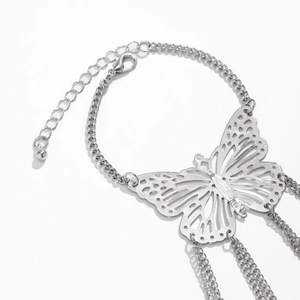 Dettaglio del bracciale gotico a farfalla in argento con design traforato e nappe lunghe