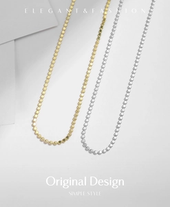 Close-up of minimalist gold and silver bead choker chain with polished metal finish