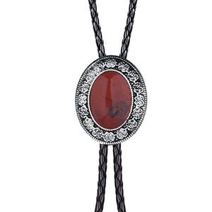 Detail of western bolo tie with red agate gemstone in vintage silver floral frame