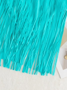 Détail des longues franges turquoise sur un maillot de bain élégant au fini soyeux et brillant