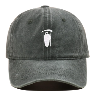 Macro view of detailed white Grim Reaper embroidery on a vintage charcoal baseball cap