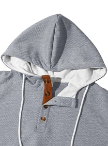 Gros plan d'un sweat à capuche gris pour hommes avec texture jacquard et col boutonné