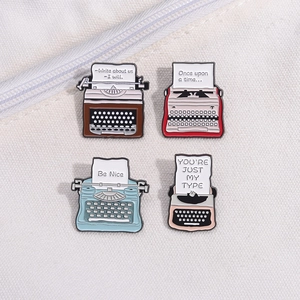 Vintage typewriter enamel lapel pins set in four colors on a white canvas background