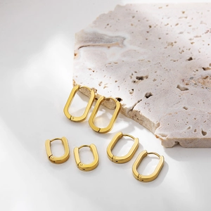 Three pairs of 18K gold plated oval hoop earrings in various sizes on stone base