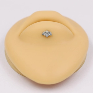 Detail of silver piercing jewelry with three marquise-cut zircons on a silicone model