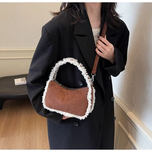 Detail of suede shoulder bag featuring lamb wool stitching and adjustable strap