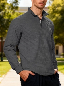 Close-up of textured dark grey waffle knit fabric and metal half-zip on the polo collar