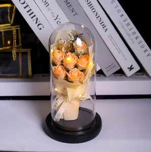 Detail of orange soap roses in glass dome with LED lights and black wood base