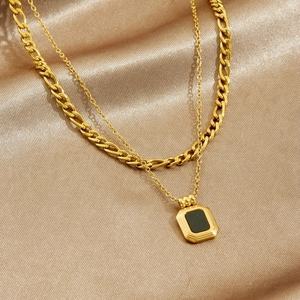 Double layered gold stainless steel necklace with black rectangular pendant on silk
