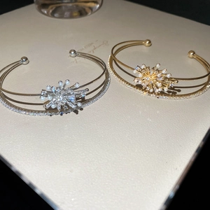 Detail view of double-layered open bangle with pearl and zircon firework design