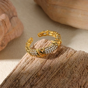 Detail of gold-plated open ring with micro-pave white zircon stones on rustic wood