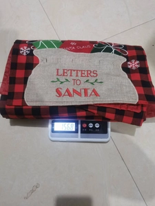 Gewichtsmeting van de kersttafelloper met een weergave van 156,8 gram