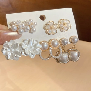 Detail view of flower and pearl earring set featuring four vintage elegant jewelry designs