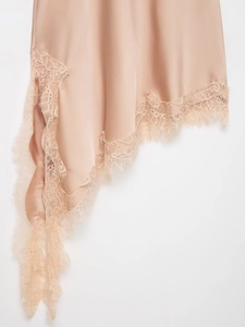 Detailed close-up of champagne satin fabric with delicate eyelash lace trim on dress hem