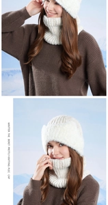 Detail of white chunky knit beanie with earflaps and matching scarf for winter warmth