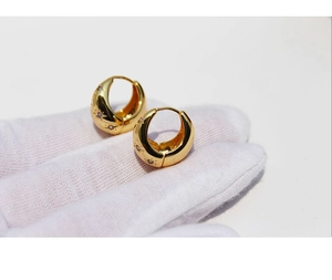 Macro shot of gold hoop earrings with starburst engravings and micro-pave cubic zirconia