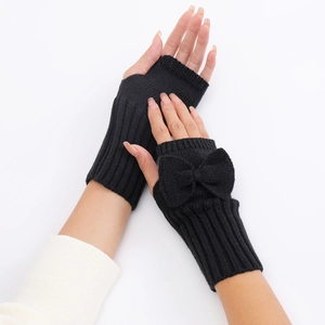 Detail of black knitted fingerless gloves with bow design and ribbed texture finish