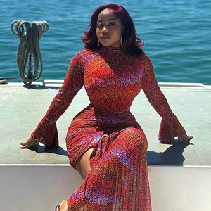 Slim fit high neck long sleeve dress with orange geometric print against a sea backdrop