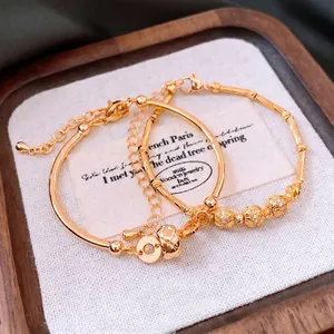 18K gold plated bamboo link and bead bracelets with round charm on linen display