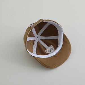 Detailed interior of a baby baseball cap showing soft lining and bear embroidery