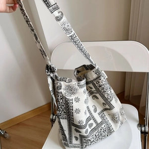 Detail of paisley print canvas tote bag with adjustable strap on a white chair