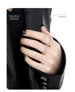 Detail showing twist design silver ring worn against a textured black background
