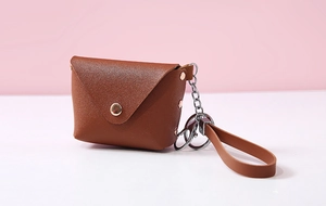 Close-up of brown PU leather mini coin purse with lychee texture and gold snap button