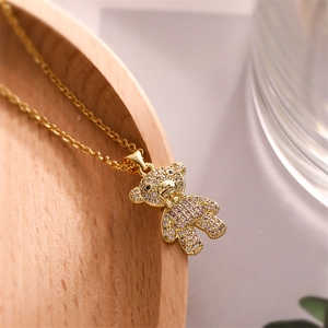 Macro shot of a 3D teddy bear pendant with crystal paving and a gold-plated necklace