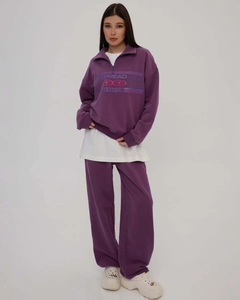 Detail view of purple two-piece sweatshirt set with half-zip design and straight pants