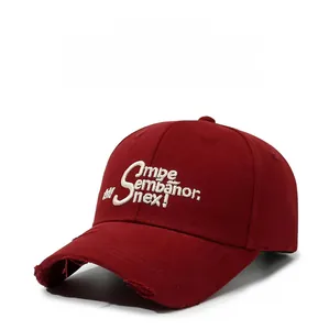 Close-up of vintage burgundy baseball cap with white embroidery and distressed brim details