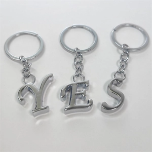 Set of YES letter metal keychains with polished silver finish on a white background