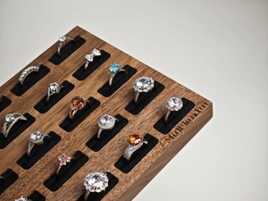 Detailed view of assorted luxury rings displayed in a dark walnut 15-slot velvet tray