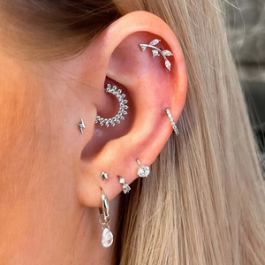 Silver geometric zircon earring set featuring lightning studs and leaf ear cuffs on a model