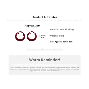 Vue détaillée des boucles d'oreilles floquées bordeaux avec dimensions et texture douce