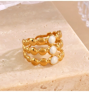 Detailed macro view of triple-layered gold geometric ring with white enamel inlays