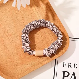 Detailed view of high-elasticity hair scrunchie with brown and white wave patterns