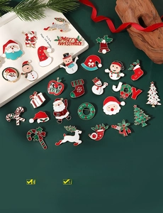 Detailed close-up of colorful enamel Christmas brooches featuring Santa, snowman, and tree