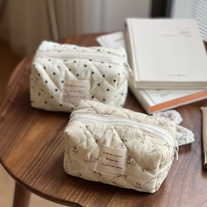 Quilted corduroy organizers with heart and floral patterns on a rustic wooden desk