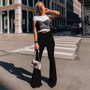 Outdoor street style shot of high-waisted leopard print flare pants with layered lace top