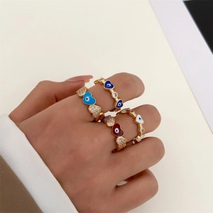 Detail of four colorful enamel heart rings with gold plating and zircon micro-inlay