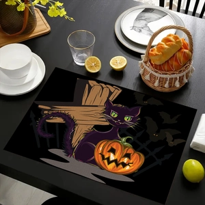 Macro detail of Halloween linen placemat featuring a black cat, pumpkin, and bat design