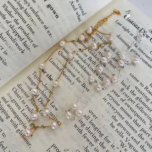Macro shot of gold and silver irregular pearl necklaces on vintage book pages