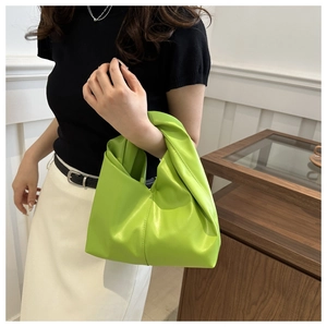 Detail of lime green tote bag featuring a unique knotted handle and smooth leather texture