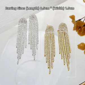 Detail view of long tassel earrings with sparkling rhinestones in gold and silver finish