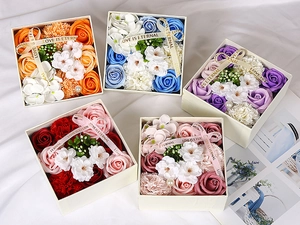 Detail view of five square soap flower gift boxes with roses and pearls in varied colors