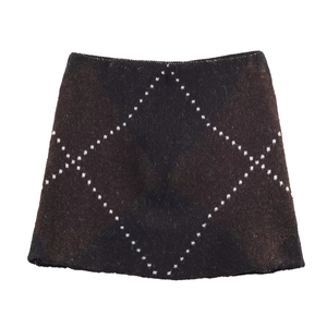 Detail of knitted coffee and black mini skirt with white dotted diamond pattern
