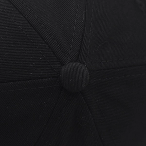 Detail van de katoenen kroon en bovenknop van deze zwarte honkbalpet met fijne stiksels erop