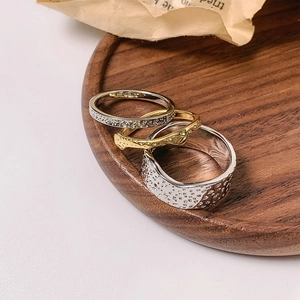 Detailed view of three stackable rings with lava texture on dark wooden tray